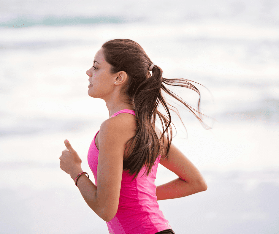 brown-haired woman running wearing a ponytail and pink shirt