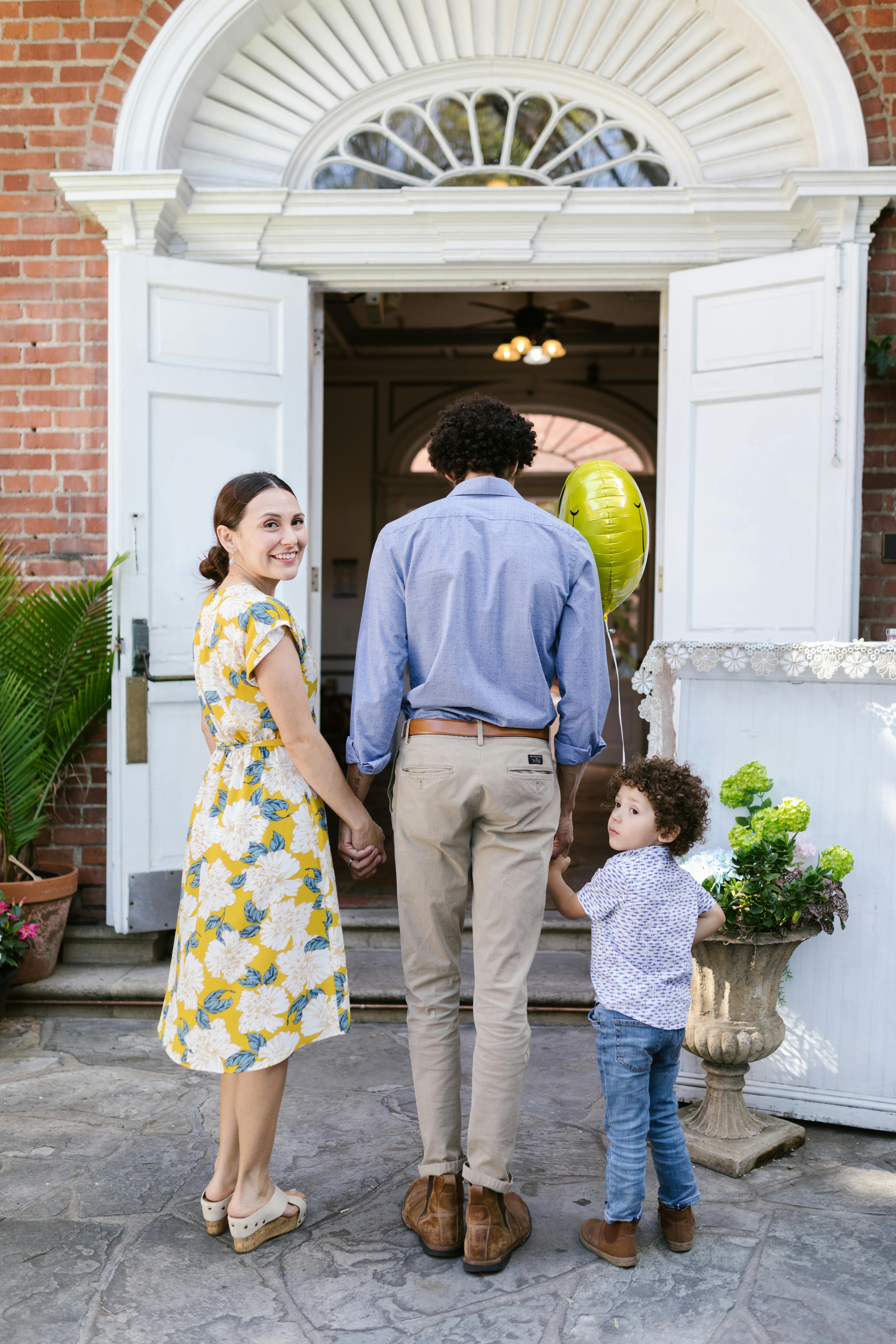 family of three walking into church with woman looking back at camera