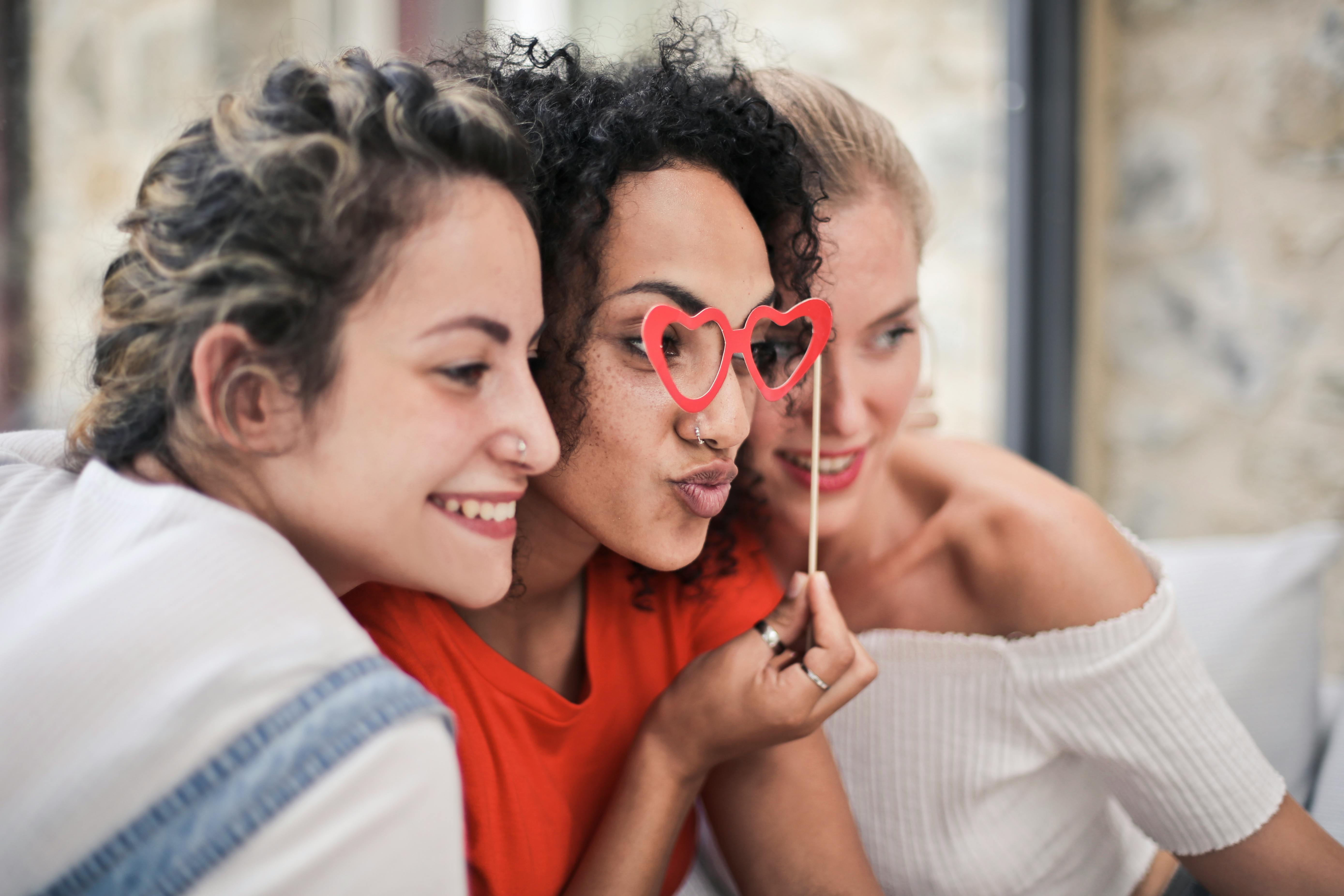 three women posing with heart shaped glasses