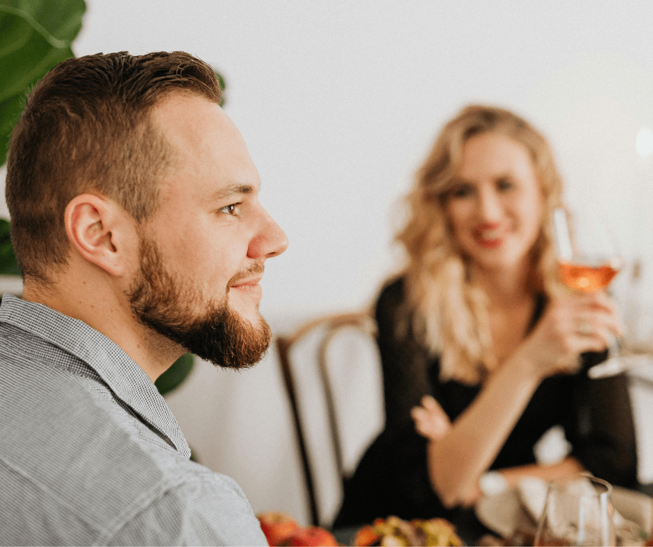 Woman gazing at a man during a romantic dinner, seated at an elegant table with wine glasses