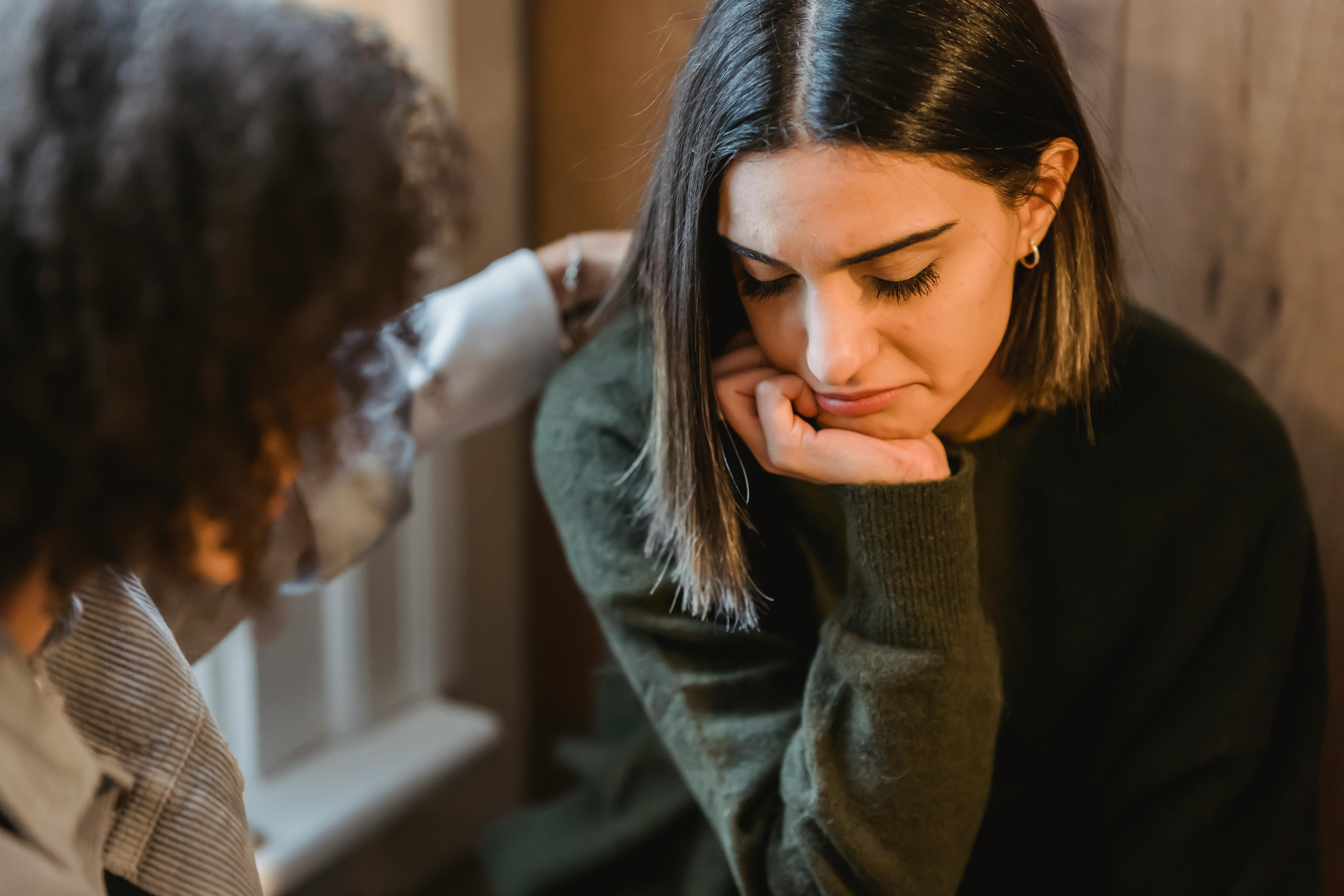 two woman comforting one another