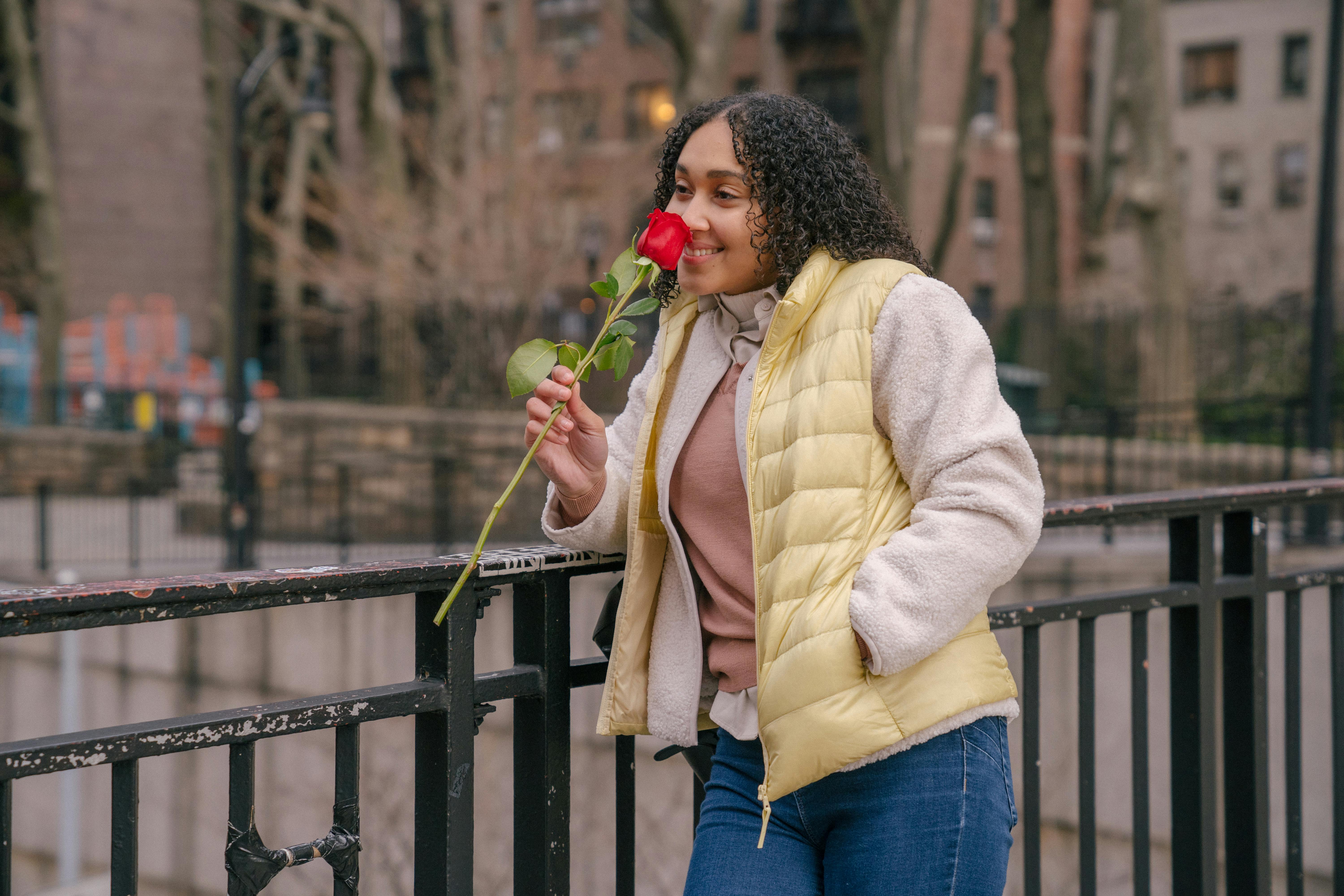 woman happily smelling the rose