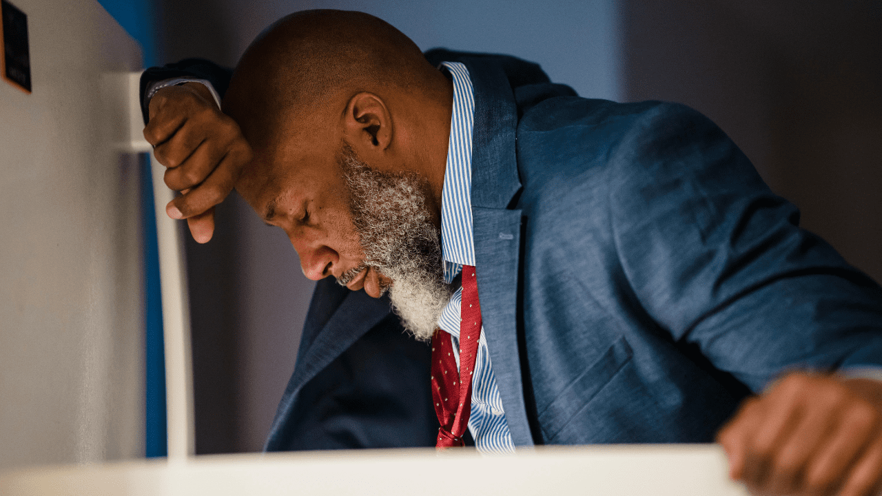 Stressed office worker in blue suit struggling with secondary trauma
