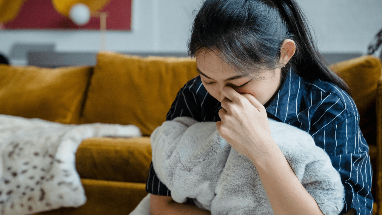 Sad woman sitting alone, showing signs of emotional distress and depression