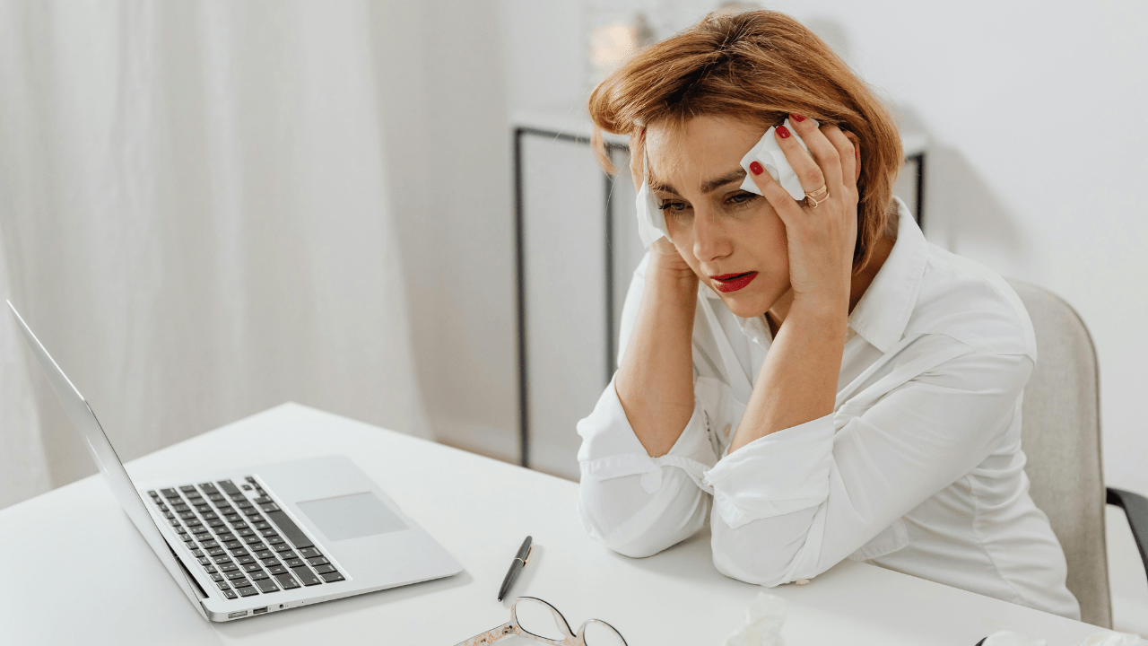 Woman in emotional distress crying at a table, reflecting trauma and mental health challenges
