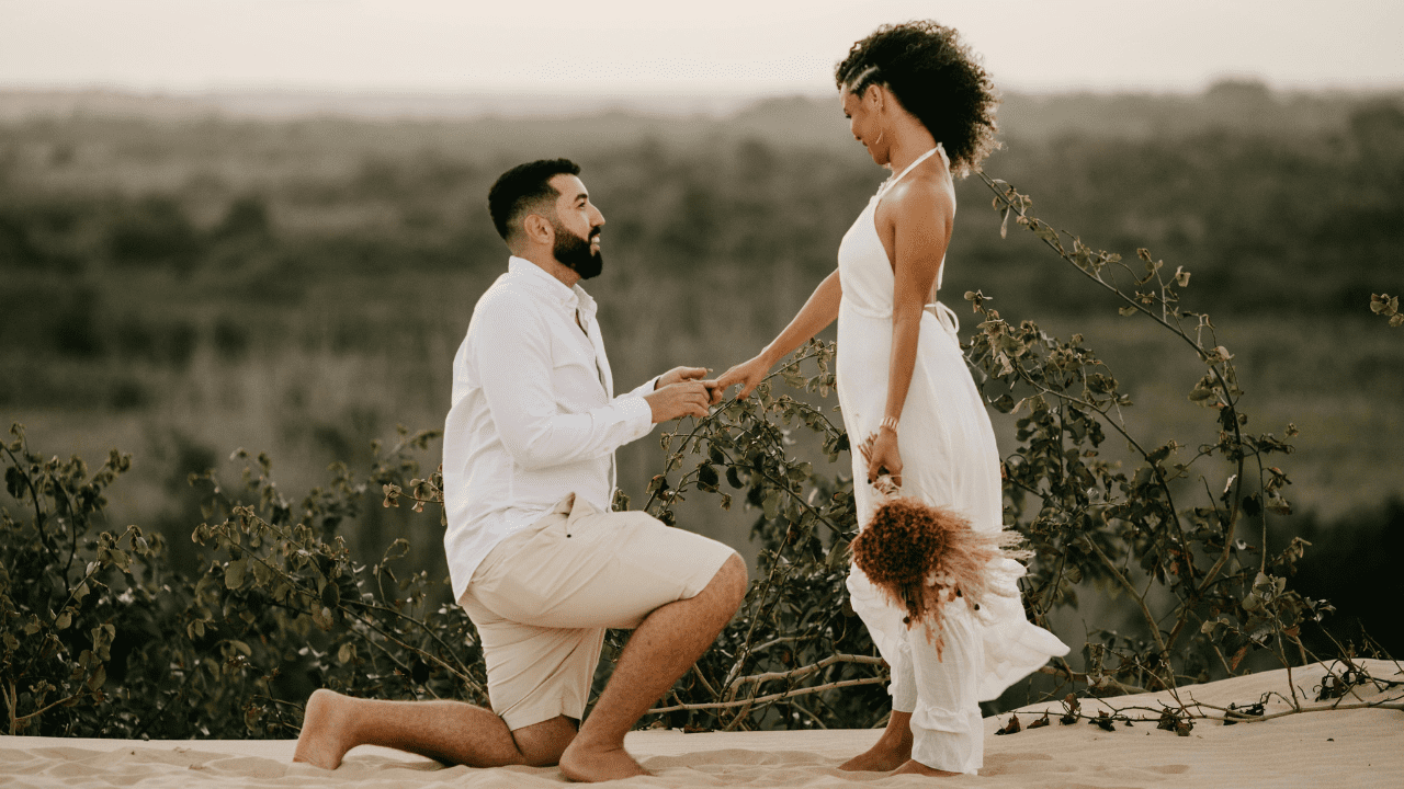 Man kneeling and proposing to woman on beach