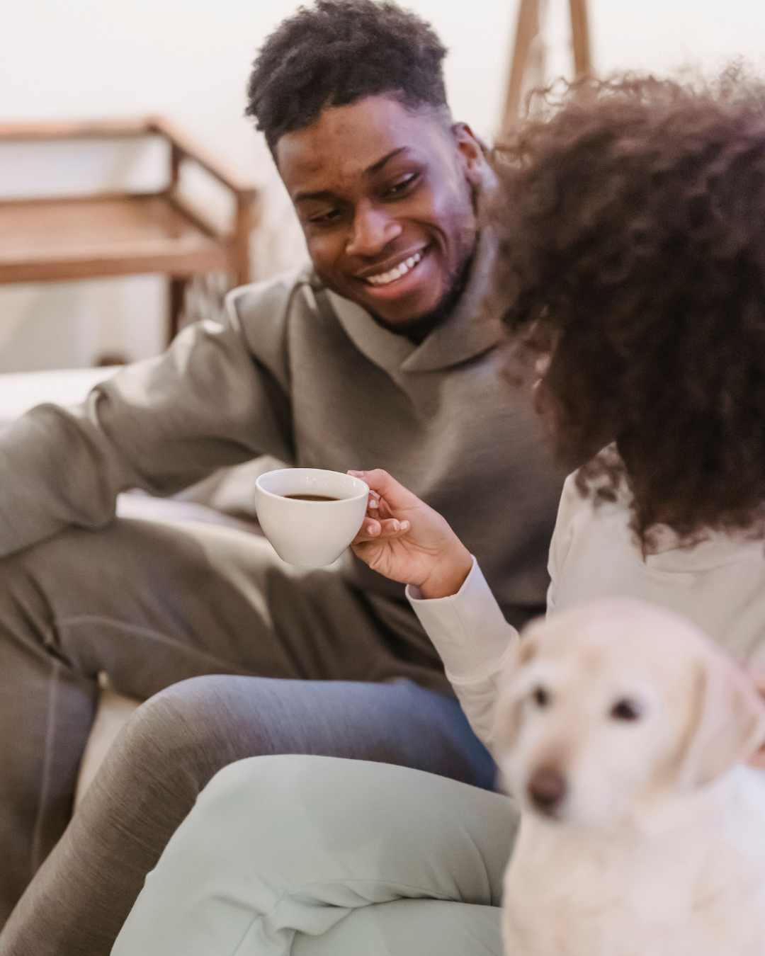 Couple sharing coffee at home with their dog, enjoying a quiet moment together