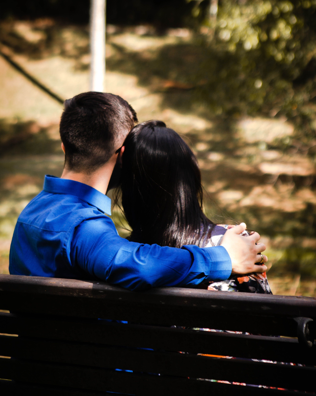 Couple sitting closely together outdoors, reflecting on their relationship
